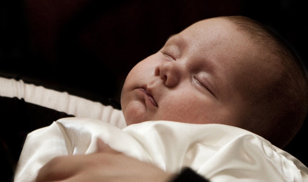 Dåbsbarn sover i dåbskjole lliturgi - Sådan foregår hjemmedåb, nøddåb og fremstilling i folkekirken
